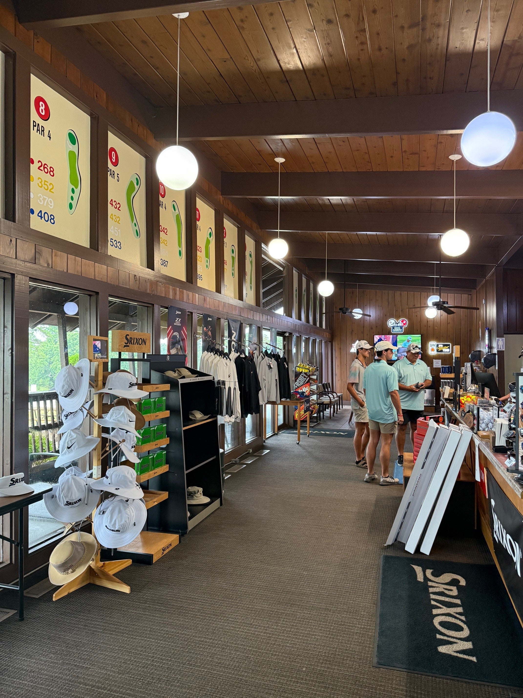 Picture of men inside a golf shop. Golf gear is also shown.