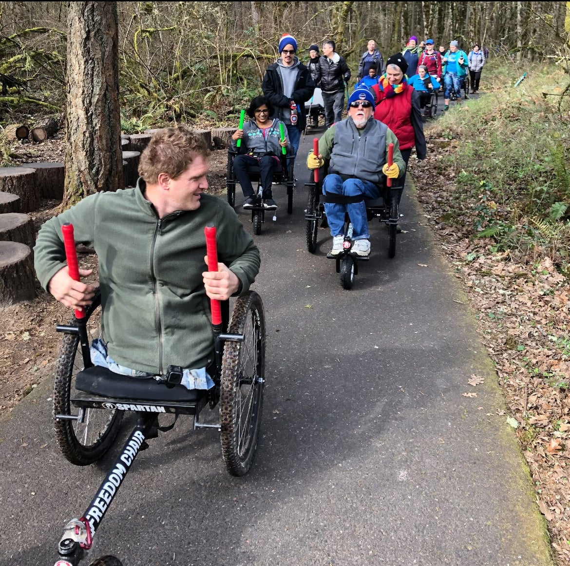 Picture of several people using a GRIT Freedom chair on a trail.